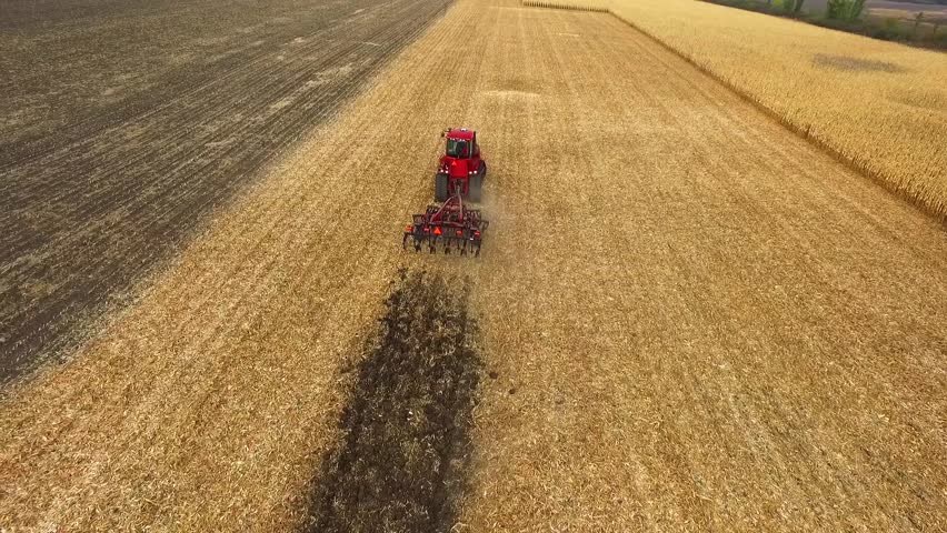 Aerial view of a red farm tractor hauling hay.